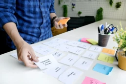 persona che attacca post it e fa brainstorming